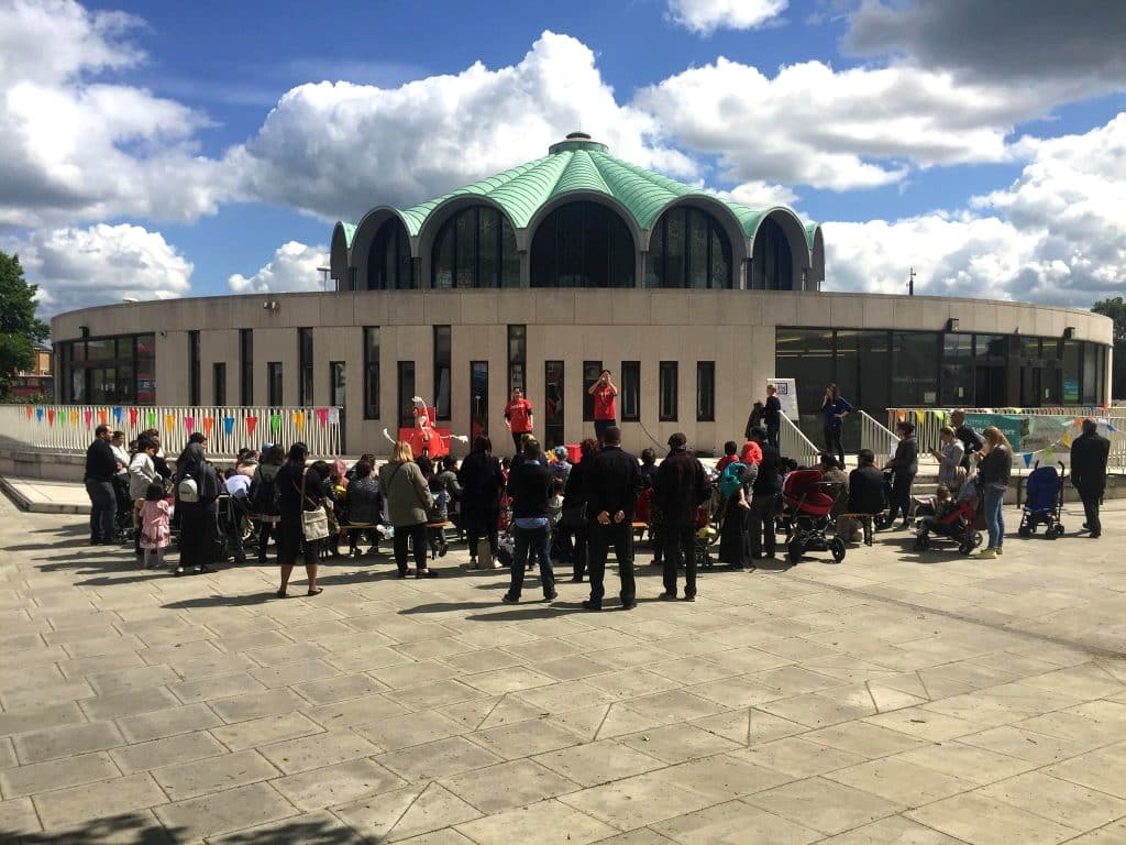 group of people gathered in the square outside the library