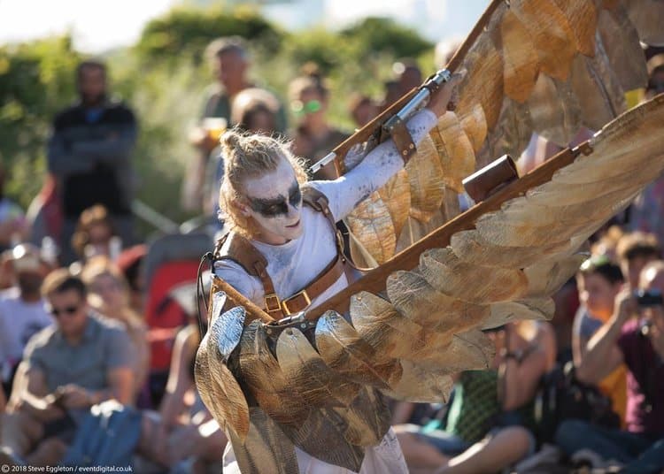 actor with wings performing outdoors