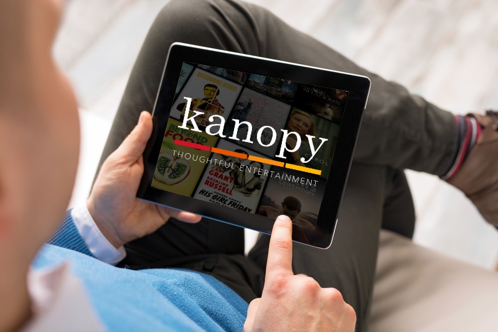 man holding tablet with kanopy on the main screen