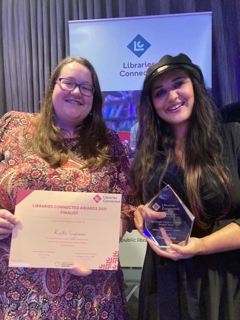 library staff smiling with award