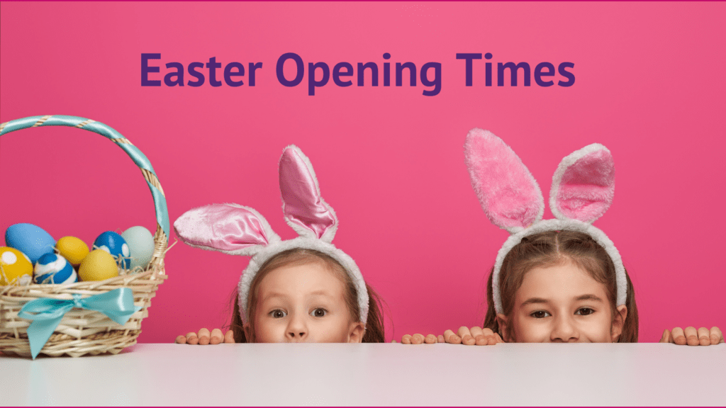 two little girls with basket of Easter eggs peering over table