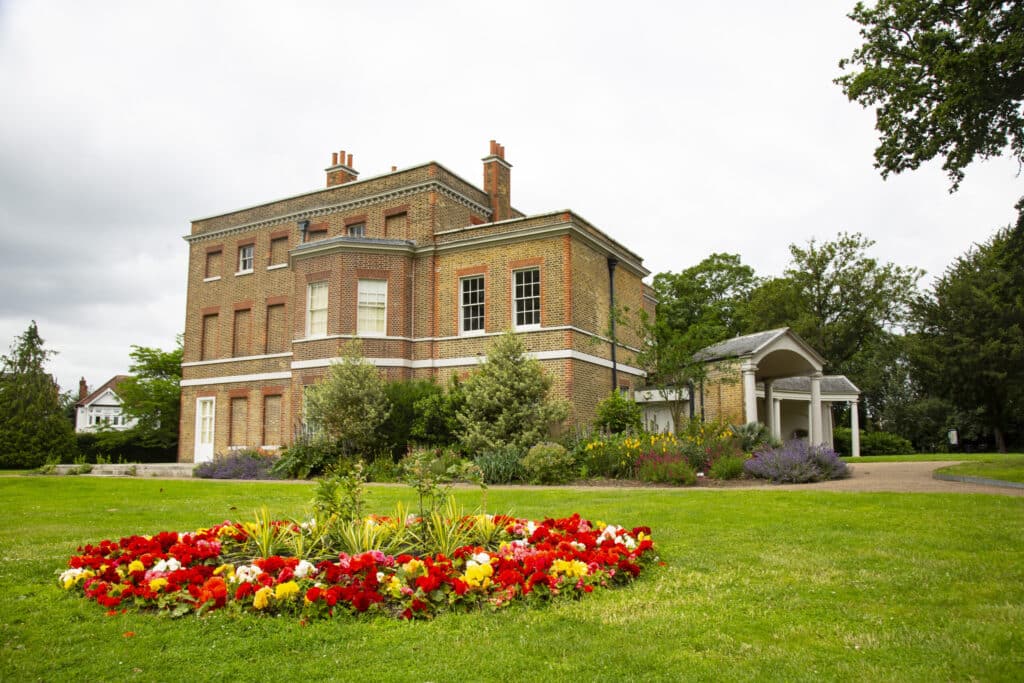 Photo of Valentines mansion with a flower bed in front.