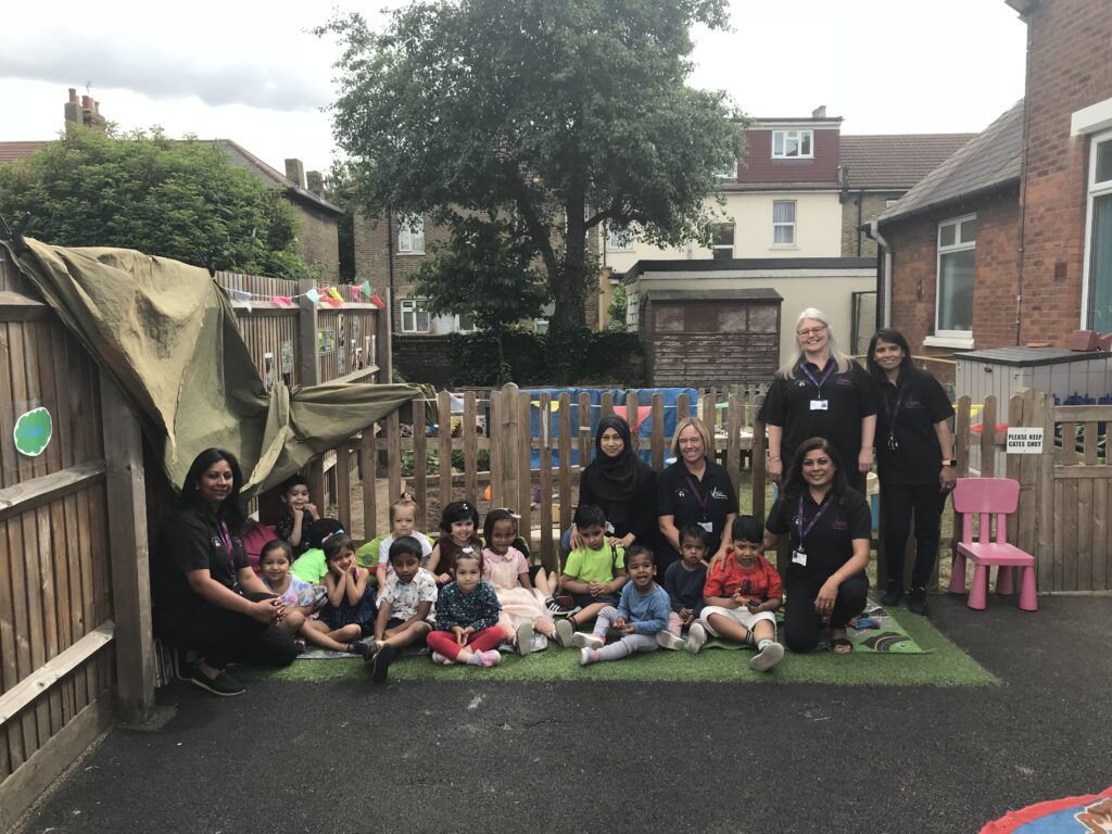 Staff and children at in garden outside Mildmay Nursery