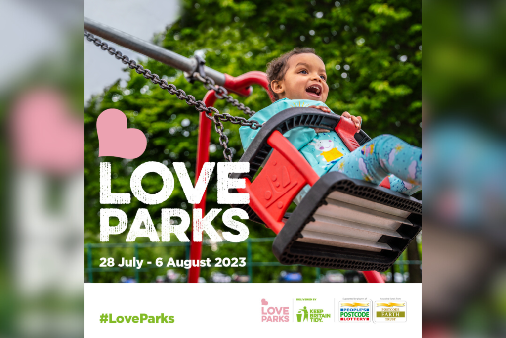 A young child smiles as they swinging in a swing at a park.