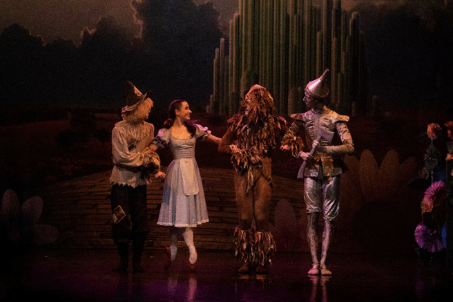 Wizard of Oz cast on the stage in full costume - the scarecrow, Dorothy, the Lion and Tin Man